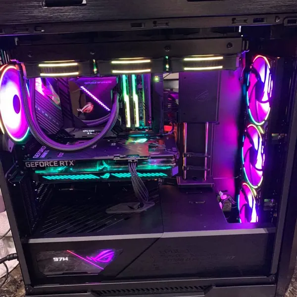 ASUS ROG gaming build with pink and teal RGB fans and a liquid cooler